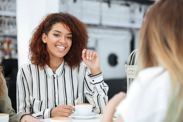 istock Happy african woman sitting in cafe 1357733353