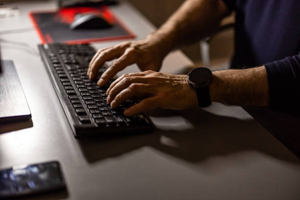 istock Mature man sitting at desk and working on laptop at night 1357734974