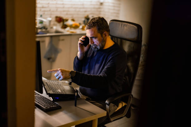 istock Handsome mature man  Specialist Working on Desktop Computer in Creative Home Living Room. 1357735022