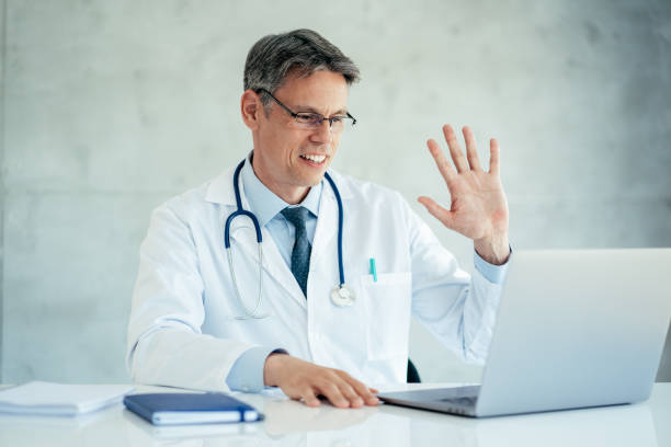 istock Doctor speaks with patient using laptop online 1357743538