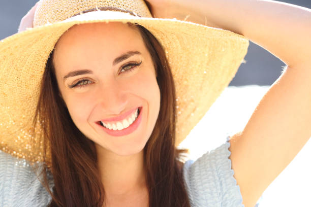 istock Happy woman smiling at camera on the beach 1357744248
