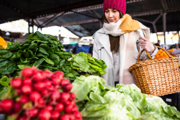 A young woman shopping for vegetables at the farmer's market stock photo