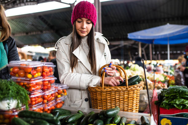 istock A pretty young woman buying cucumbers 1357746405