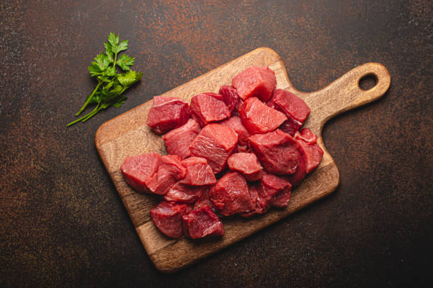istock Beef raw meat cubes for stew on wooden cutting board 1357746904