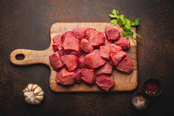 istock Beef raw meat cubes for stew on wooden cutting board 1357746914