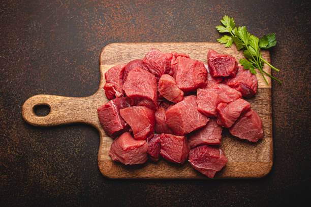 istock Beef raw meat cubes for stew on wooden cutting board 1357746917