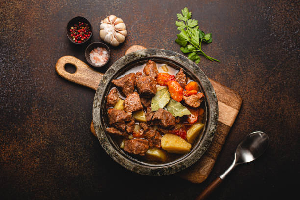 istock Meat beef stew with vegetables and gravy in rustic metal pot top view 1357746924
