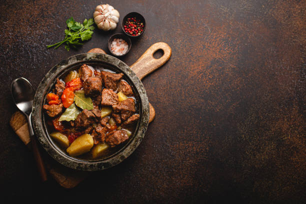 istock Meat beef stew with vegetables and gravy in rustic metal pot top view copy space 1357746926