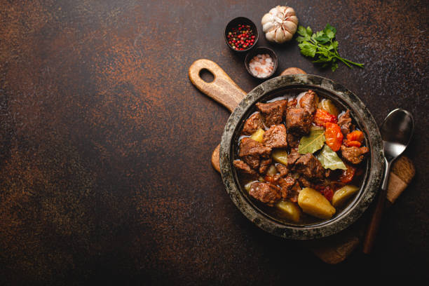 istock Meat beef stew with vegetables and gravy in rustic metal pot top view copy space 1357746932