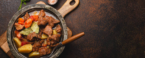 istock Meat beef stew with vegetables and gravy in rustic metal pot top view copy space 1357746947