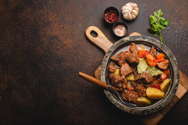 istock Meat beef stew with vegetables and gravy in rustic metal pot top view copy space 1357746959