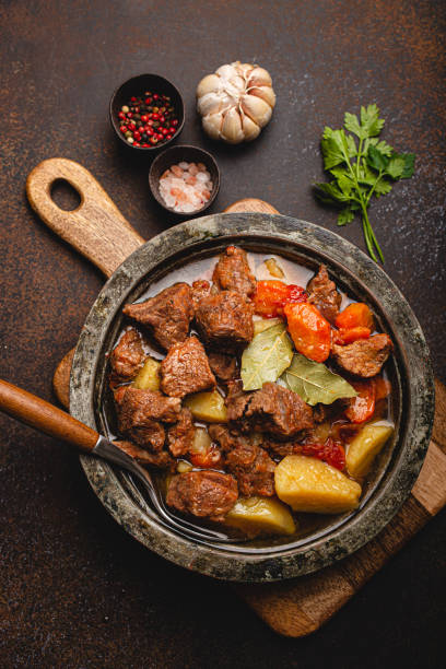 istock Meat beef stew with vegetables and gravy in rustic metal pot top view 1357746965