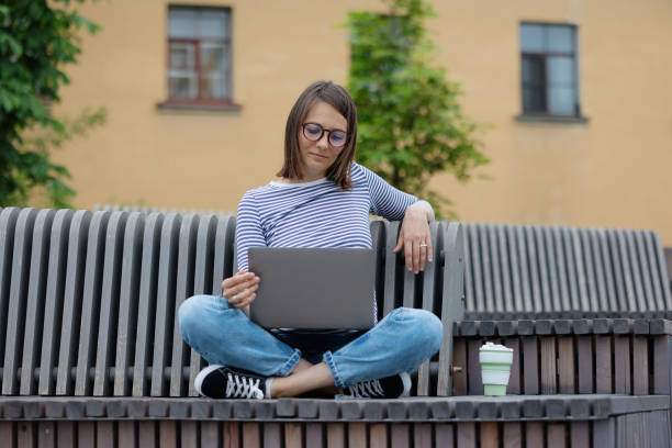 istock young and confident woman blogger or marketer drinking coffee and working on her laptop. work in a park or public place. social media or work as a top manager 1357750468