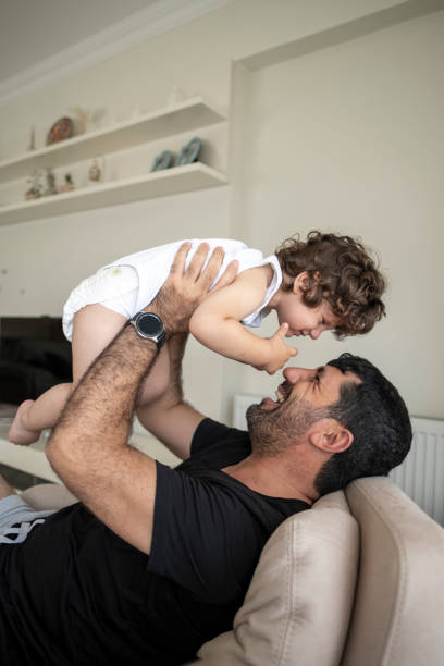 istock Happy dad and Baby son relax on couch together 1357751364