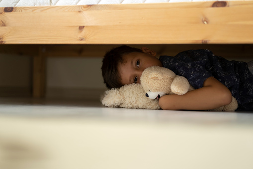 Child hiding under the bed
