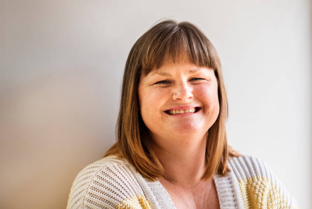 istock Woman leaning against a wall at home and smiling 1357751739