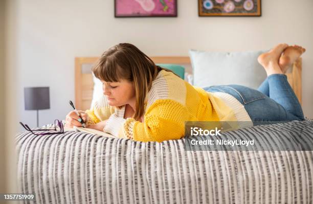 Woman Lying On He Bed And Writing In A Journal Stock Photo - Download Image Now - Copy Space, Wellbeing, 35-39 Years