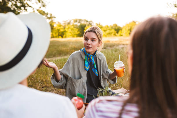 istock Pretty girl holding juice in hand thoughtfully discuss something 1357752955