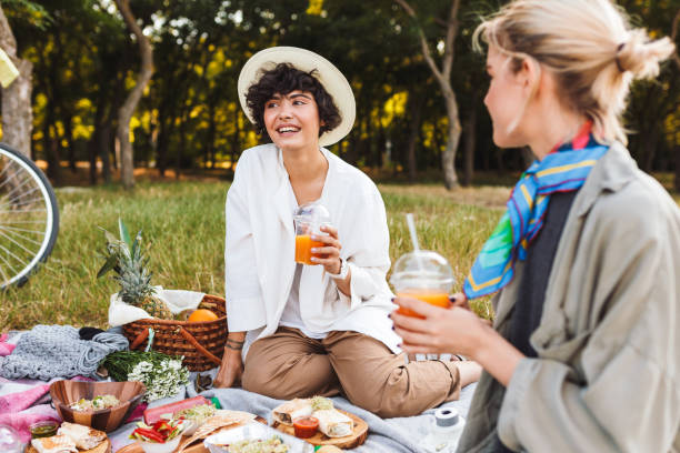 istock Pretty girl holding juice in hand dreamily looking aside while h 1357754772