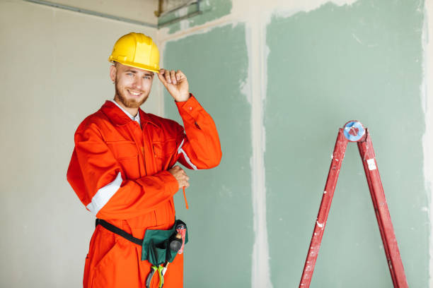 istock Young foreman in orange work clothes and yellow hardhat joyfully 1357755470