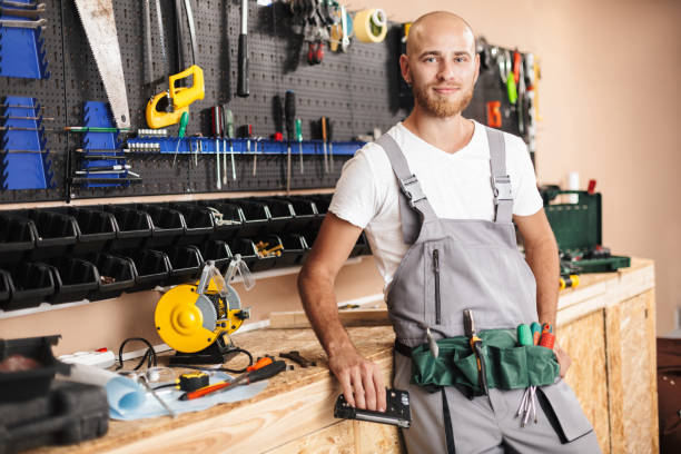 istock Smiling foreman in work clothes holding stapler in hand dreamily 1357759447