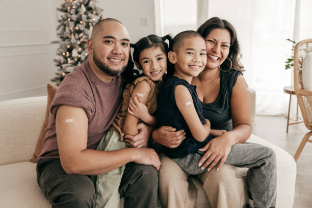 istock Smiling family sitting on sofa all vaccinated 1357759615