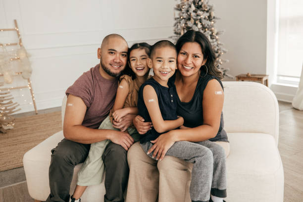 istock Smiling family sitting on sofa all vaccinated 1357759616