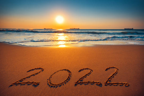 istock New Year 2022 text ettering on the beach sand. Sea sunrise. 1357760473