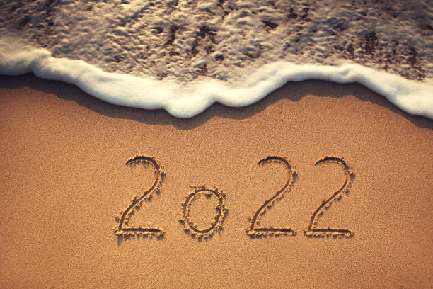 istock 2022 new year text on the beach sand and sea wave 1357760645