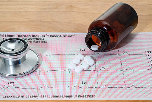 An ECG test chart with pills and a stethoscope