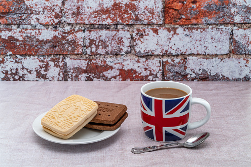 British mug printed with a UK Union Jack flag with a custard cream and a chocolate bourbon cookie biscuit