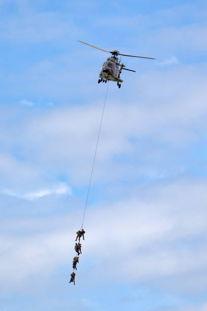 hélicoptère utilitaire militaire aerospatiale as532 des forces aériennes suisses transportant des troupes par suspension de corde. - as532 photos et images de collection