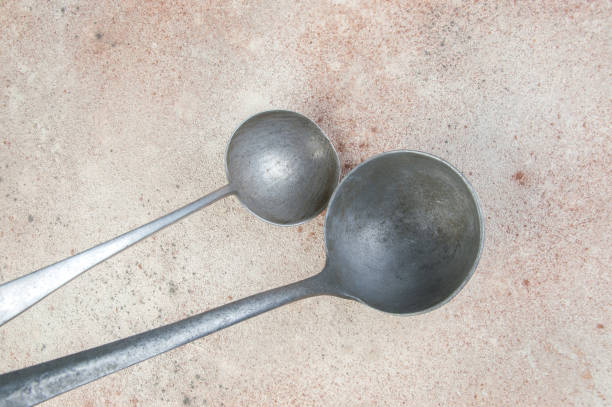 istock Two aluminum ladles on concrete background 1357762843