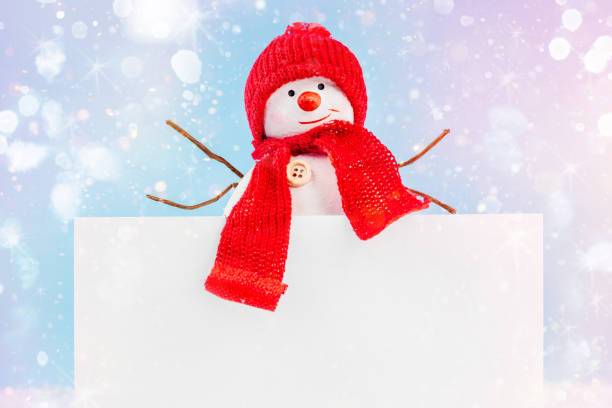 istock A snowman in his hands holds a frame for text on a blue background.Copy space.New Year's card background.Christmas home decor.Simple minimalistic. 1357765324