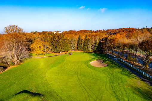 empty golfcourse at autumn and the clubhouse on the hill