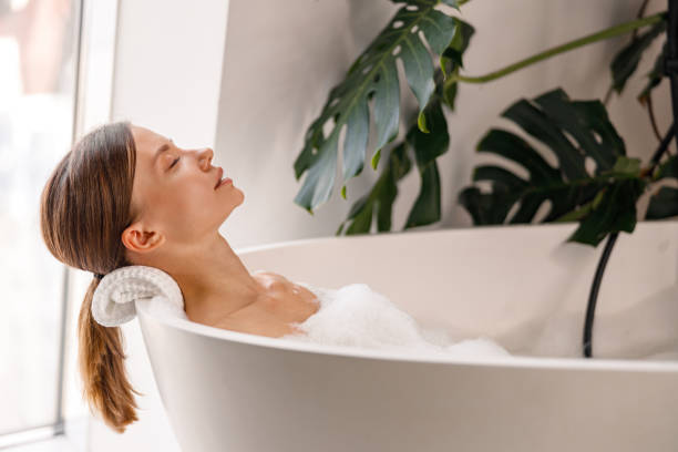 럭셔리 스파 리조트에서 거품 목욕을하면서 눈을 감고 휴식을 취하는 아름다운 젊은 여성의 측면 보기 - bathtub women naked human face 뉴스 사진 이미지