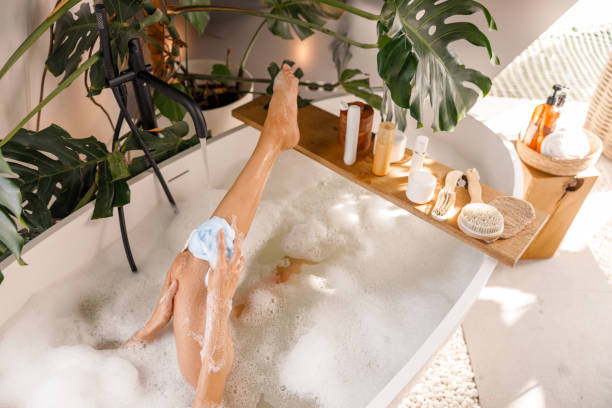 istock High angle view of young woman using sponge while bathing, relaxing in bubble filled bathtub 1357768879