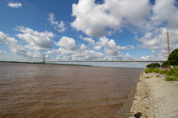 breites foto der humber bridge, in der nähe von kingston upon hull, east riding of yorkshire, england, einfeldrige straßenhängebrücke, aufgenommen an einem sonnigen tag mit ein paar weißen wolken am himmel. - humber bridge bridge humber river yorkshire stock-fotos und bilder