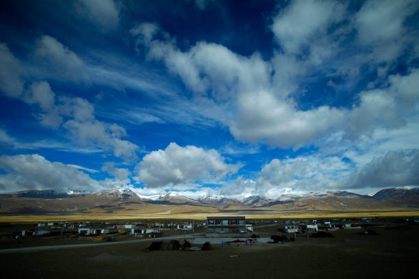 istock The blue sky white clouds and grassland snow mountain landscape 1357772450