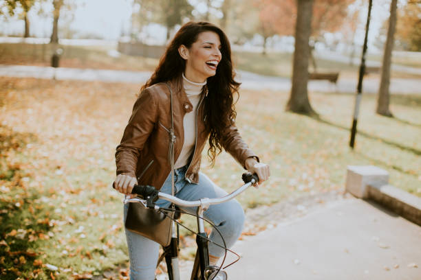 istock Young woman riding bicycle on autumn day 1357775626