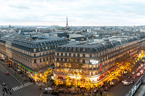 View over the rooftops of Paris, during Christmas with Galeries Lafayette in foreground and Eiffel Tower in background. Paris in France. December 2, 2021