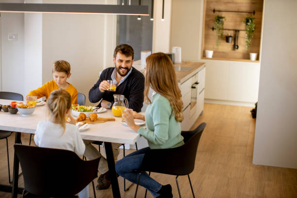 istock Young happy family talking while having breakfast at dining table 1357776641