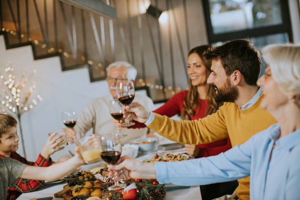 istock Happy family having dinner with red wine at home 1357776696