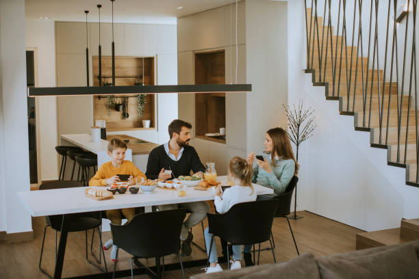 istock Family using mobile phones while having breakfast at dining table at apartment 1357776723