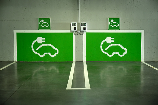 imagen de un aparcamiento con dos puntos de recarga de coches eléctricos pintados de verde en la pared photo
