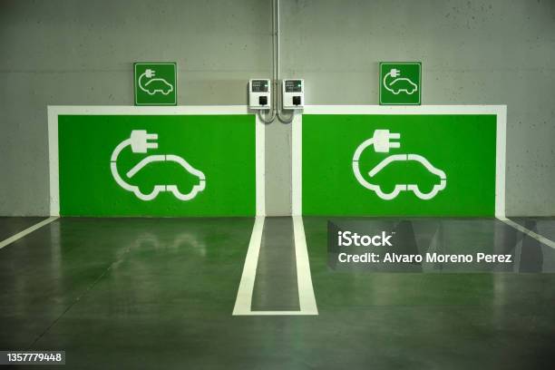 Image Of A Parking Lot With Two Electric Car Charging Points Painted Green On The Wall Stock Photo - Download Image Now