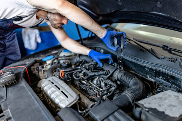 un jeune mécanicien automobile de sexe masculin résout des problèmes avec des mécaniciens sur un moteur de voiture. - adjustable wrench expertise work tool maintenance engineer photos et images de collection