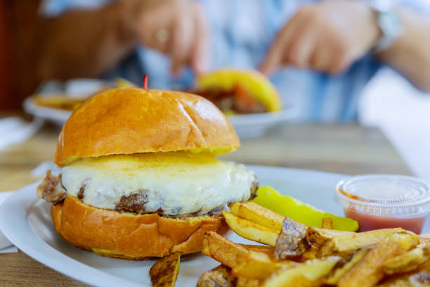 istock Hamburger with cheese and fried potatoes on a table 1357785539
