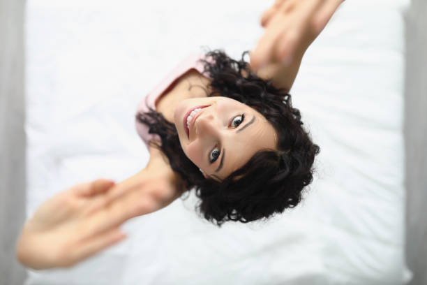 istock Young cheerful woman jumping on bed after waking up 1357786189