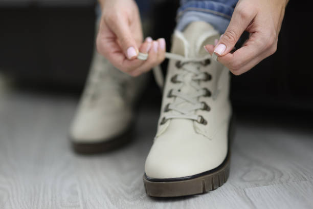 istock Woman put her white boots on and tie laces before going out 1357786201
